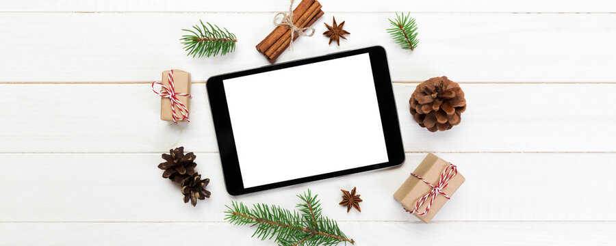 Digital tablet mock up with rustic Christmas wooden background decorations for app presentation. top view with copy space