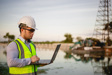 Engineer is inspecting the construction site and planning the construction of an office building for a factory.