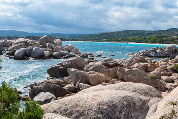 Sonniger Strand mit Felsen und hellblauem Wasser, Korsika