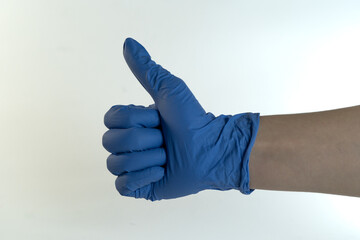 A hand in a blue rubber glove showing a thumbs-up gesture, symbolizing safety and hygiene.