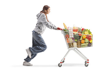 Female teenager running with a full shopping cart