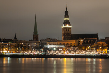 Riga, Latvia A view at night of the Daugava River bank with Christmas decorations and the Riga Cathedral.