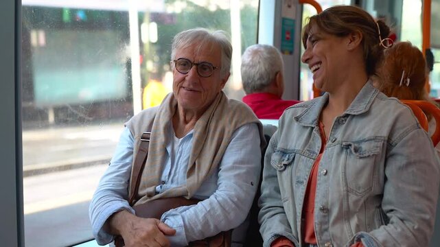 Senior man sitting inside tram with adult daughter - Elderly nursing care and travel concept	