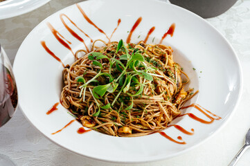 Asian noodles in a plate with sauce and vegetables. photos for the menu