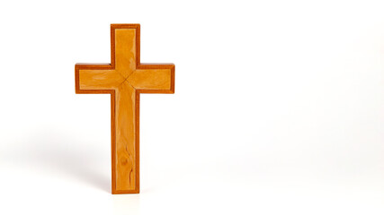 Wooden cross stands on a white surface
