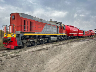 Iconic red fire train positioned on tracks beneath a beautifully dramatic sky