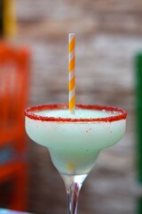 margarita drink glass mexican drink with red fruit sugar on the rim and yellow straw