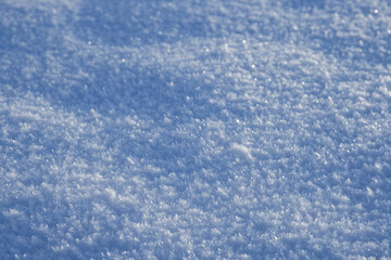Glitzernde Raureifkristalle auf weissem Schnee