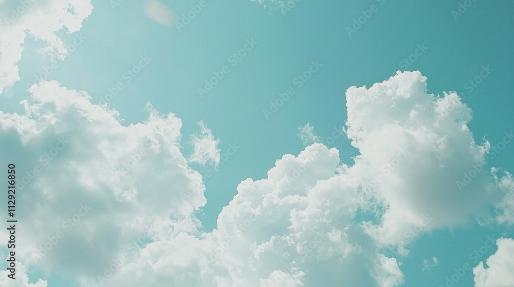 Poster beneath the vast blue canopy, soft white clouds drift lazily through the sky, creating a tranquil an