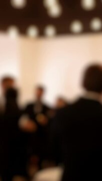 blurred scene of , Businessman is holding a cocktail glass while networking with colleagues at a formal event