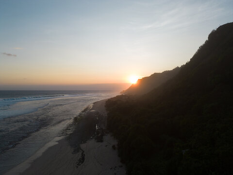 A breathtaking sunset over a tranquil beach with waves gently lapping the shore.