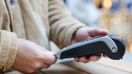 Customer inserting credit card into pos terminal for contactless payment