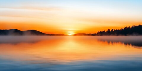 Fototapeta premium Natural transpiration concept. Serene sunset over a calm lake with mist and silhouettes of hills in the background.