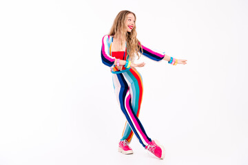 Young woman in a trendy striped outfit dancing happily against a white background, exuding a...