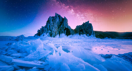 Landscape of Shamanka rock and milky way on sky with natural breaking ice in frozen water on Lake...