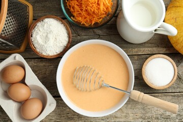 Bowl with dough and ingredients for pumpkin pancakes on wooden table, flat lay
