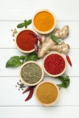 Different aromatic spices on white wooden table, flat lay