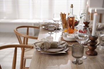 Stylish table setting with dishware, cutlery and burning candles indoors