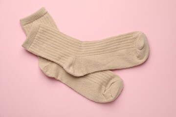 Pair of soft socks on pink background, top view