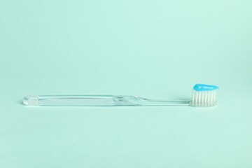Toothbrush with toothpaste on light blue background