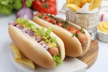Tasty hot dogs served on white table, closeup