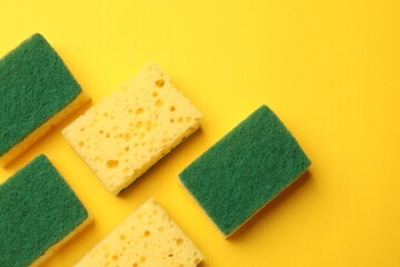 Soft sponges on yellow background, flat lay. Cleaning tool