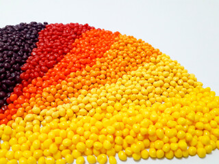 Various colors of masterbatch granules arranged on a white background, polymer carrier of color pigments in the plastic industry. Suitable for plastic company catalog design