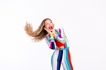 Vibrant young woman in colorful striped jumpsuit posing joyfully against a clean white background