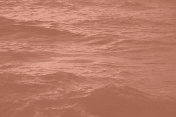 Mocha Mousse toned sea water texture. Pool water with sun reflections. Trendy colour 2025 year.