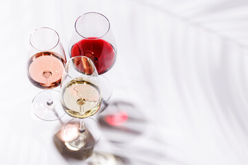 Three wine glasses filled with red, white, and rose wine