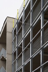 Modern parking garage structure showing steel beams and wire mesh facade