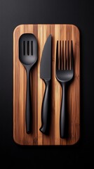 A stylish arrangement of black kitchen utensils on a wooden cutting board against a dark background.