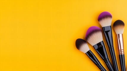 A vibrant arrangement of makeup brushes on a yellow background, showcasing various brush shapes and colors.