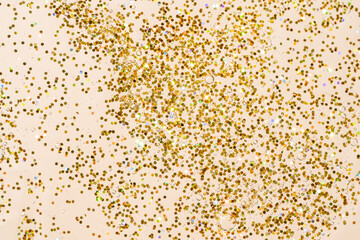 golden glitter gel background on beige background. sparkling confetti in gel texture.