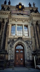 the majestic facade of the academy with elements of classical architecture. Large columns and sculptures decorating the entrance