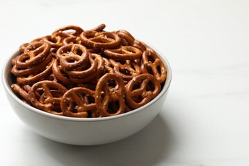 Tasty pretzel crackers in bowl isolated on white