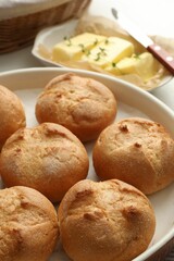 Baking dish with homemade tasty buns on table, closeup