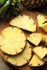 Slices of fresh ripe pineapple on wooden table, top view