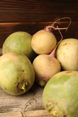 Whole fresh turnips on wooden table, closeup