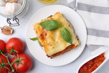 Delicious cooked lasagna and ingredients on light table, flat lay