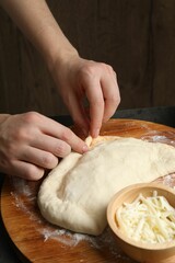 Woman making calzone pizza at grey table, closeup
