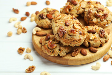 Tasty cookies with nuts on white wooden table, closeup
