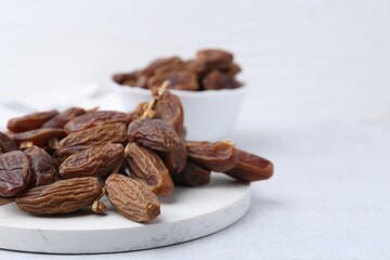 Tasty dried dates on light table, closeup. Space for text