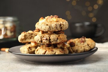Tasty cookies with nuts on gray textured table, closeup