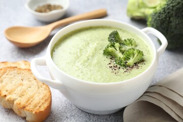 Delicious broccoli cream soup served on light table, closeup