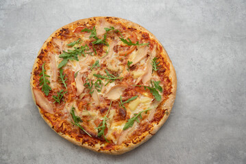 pizza with bacon, pineapple and herbs on the table