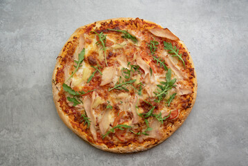 pizza with bacon, pineapple and herbs on the table