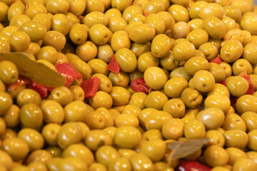 Macro shot of green olives on a market counter. Perfect for food-related content, Mediterranean dishes, healthy lifestyle, or fresh produce visuals.