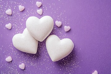 Obraz premium Three large white hearts are elegantly arranged with smaller white hearts on a soft purple background, creating a romantic Valentine's Day scene.