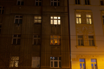 A large building adorned with numerous windows is beautifully illuminated during the night hours,...